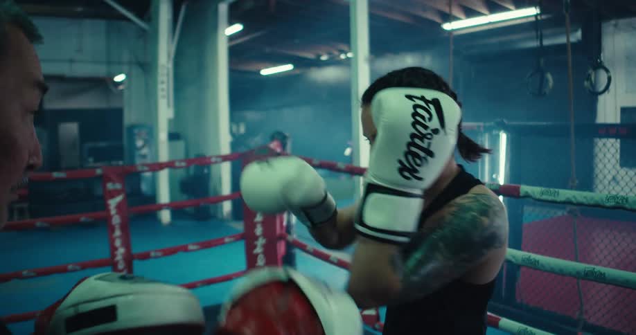A woman is sparring in the boxing ring