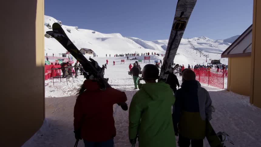 Skiers carry their equipment at a ski resort