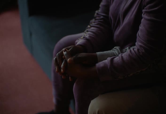 A couple are holding hands on the couch