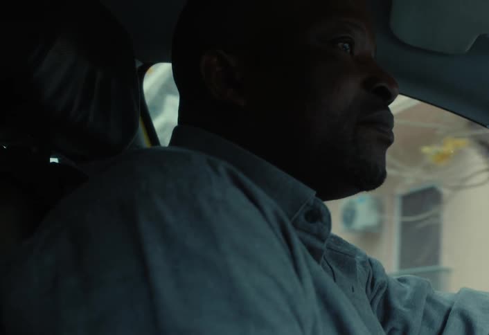 A man looks back and forth as he drives