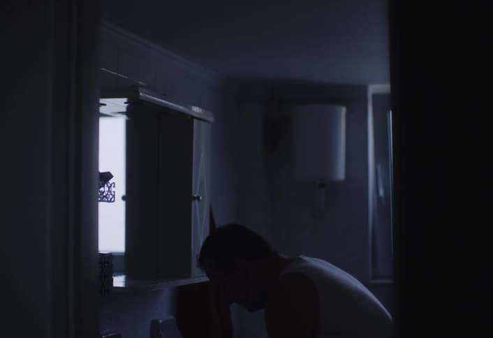 A man washes his face in the bathroom