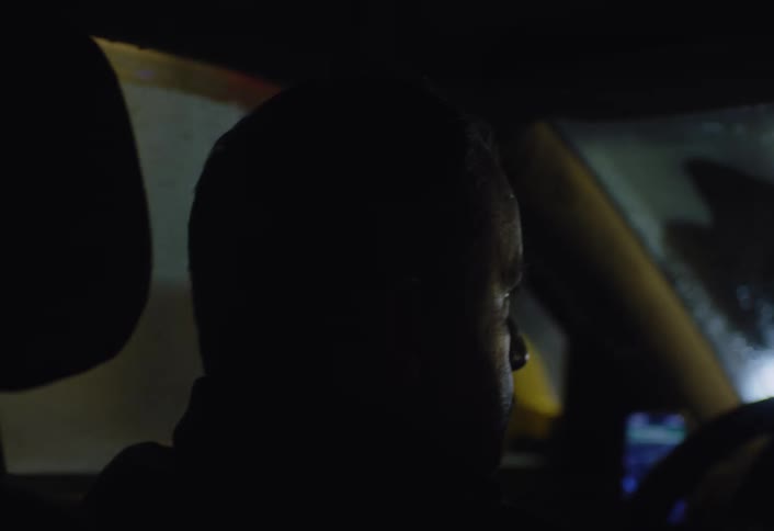A man is driving at night during a rain storm
