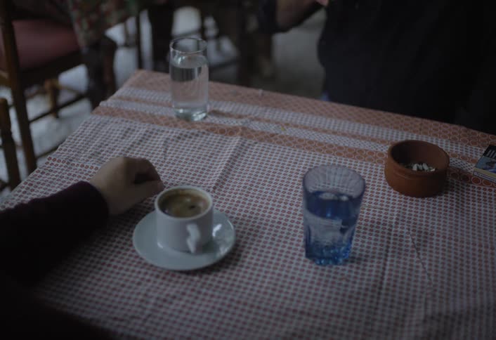 Two men are at a table in a restaurant drinking coffee drinks