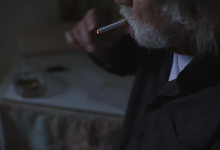 A close up footage of an elderly man smoking