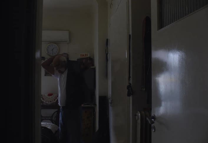 A footage of an elderly man putting on a dress indoor