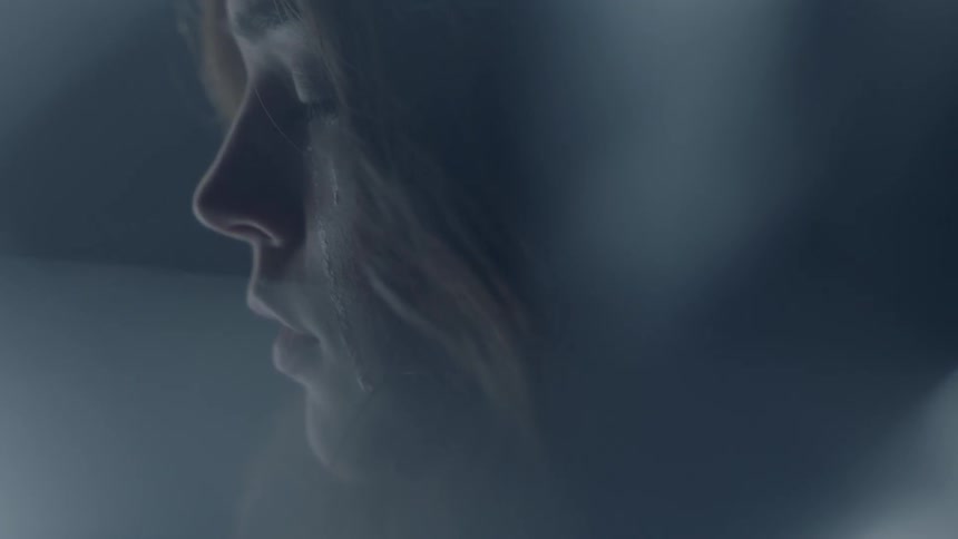 A woman in a room with tears running down her face