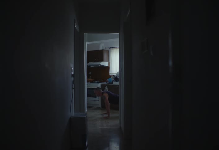 A man does pushups down the hall