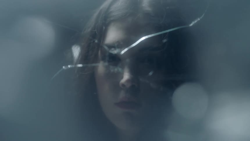 A woman looks through the hole in this glass pane