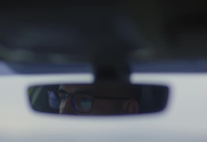 A footage of a man driving a car