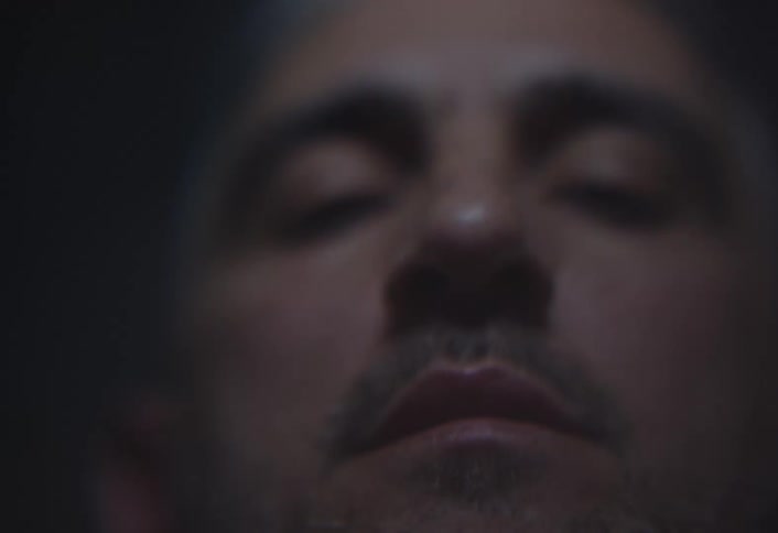 A mans face moves and goes out of focus