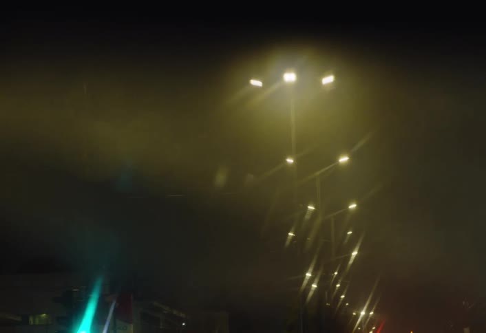 Reflection in the rearview mirror of a man driving a vehicle on a city road at night
