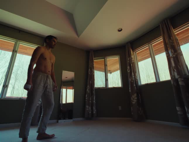 A man is dancing by the windows