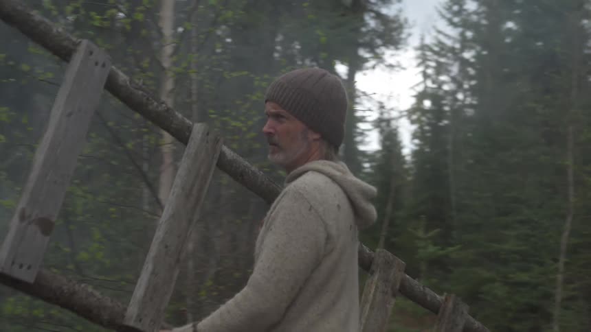 A man carries a makeshift ladder over to his tent