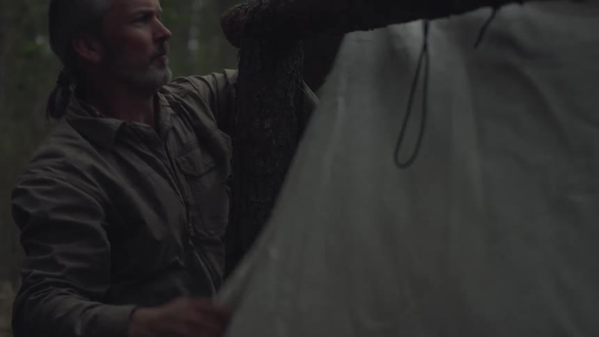 A man is quickly setting up his tent