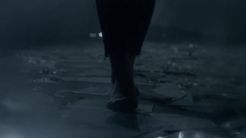 A person is walking over glass with bare feet