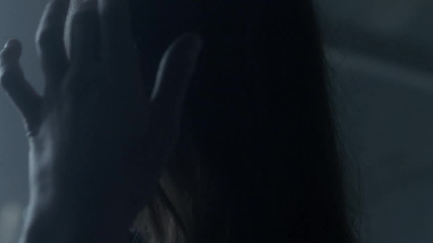 A sad looking woman tucks her hair behind her ear