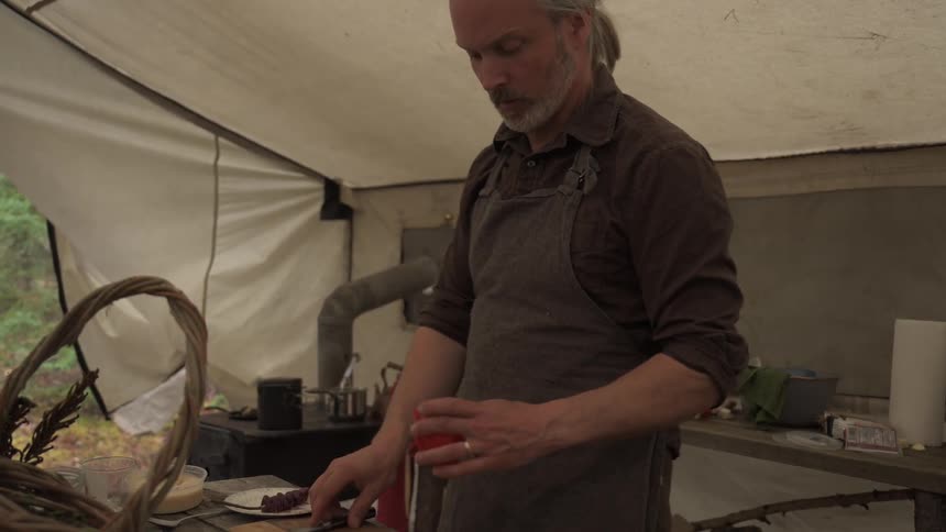 A man cuts up a pepper in the tent