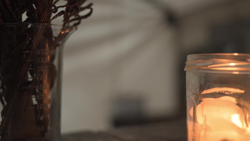 A candle is lit on a table near home decor