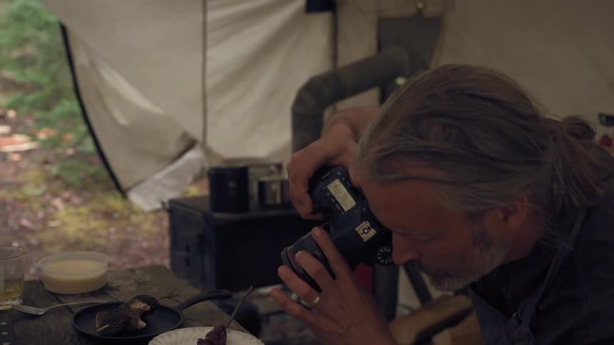 A man is photographing food in the tent