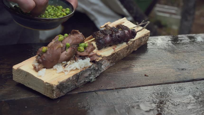 A man is preparing food on a plank