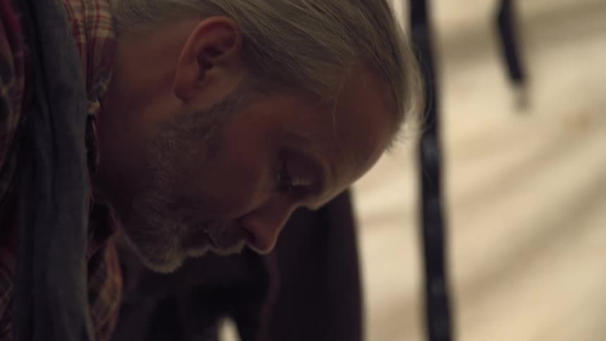 A man leans down working on something