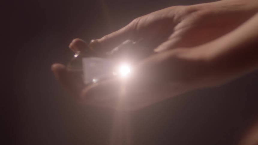 A person holding broken glass and the sun reflecting off of it