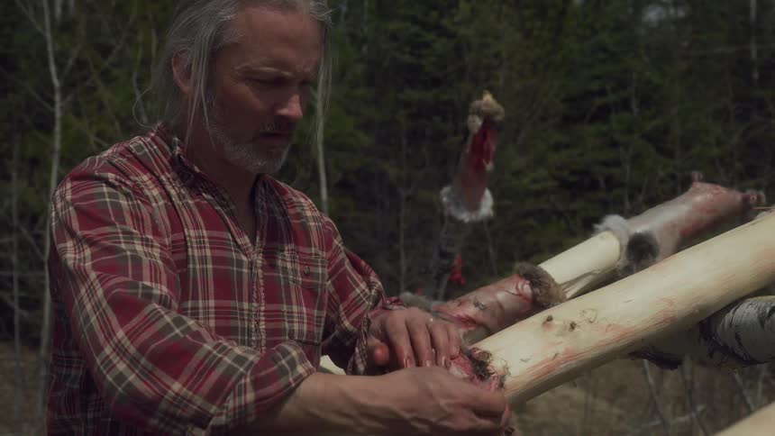 A footage of a man sunning an animal skin