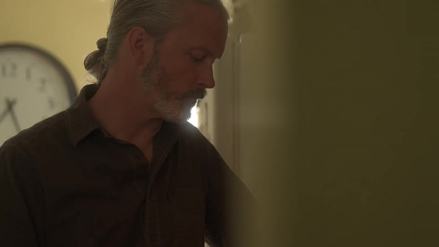 A man is standing in his kitchen