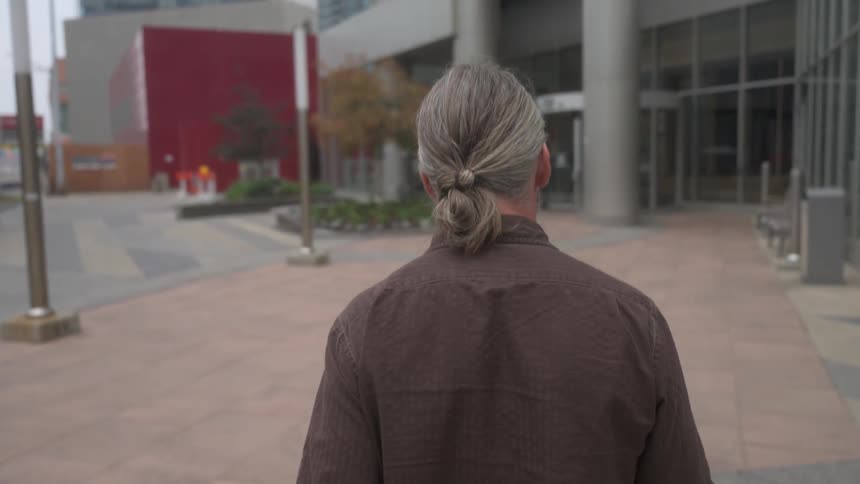 A man crosses the street headed towards a building