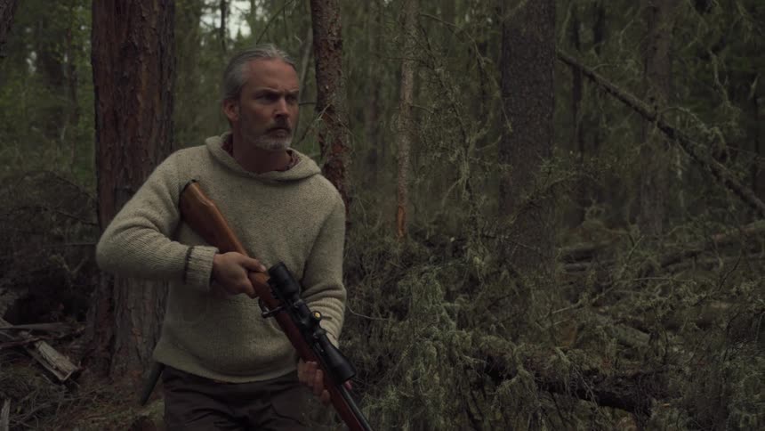 A footage of a person hunting with a gun