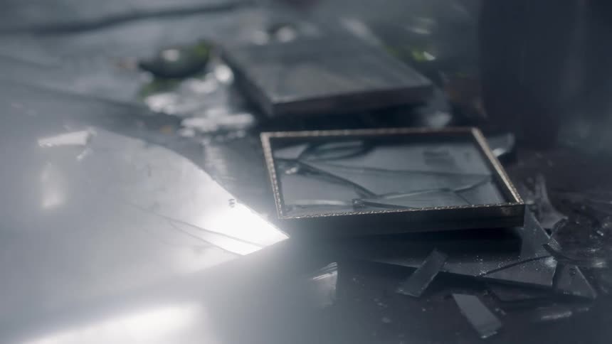 The items on the ground are all broken and shattered as a person picks up an item