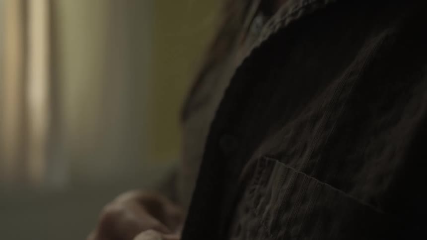 A footage of a person buttoning a jacket