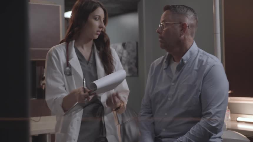 Female doctor talks with her patient while in an examination room