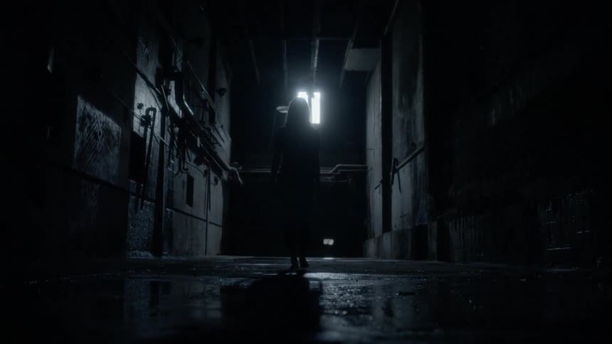 A person walking in a hallway that is wet