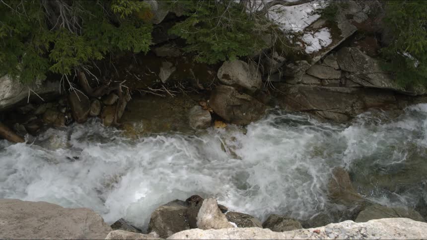 The stream below has water crashing on the rocks