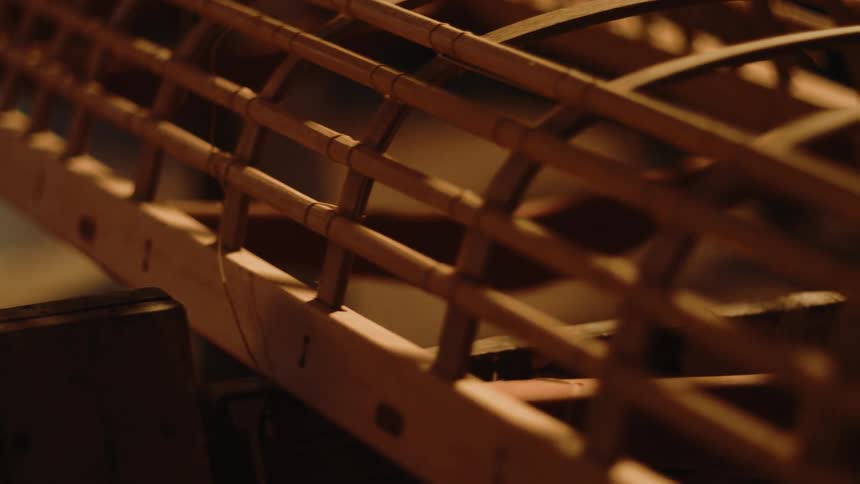 A closeup of the intricate wooden framework of a canoe highlighting its craftsmanship and design