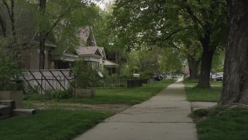 The sidewalk is empty on this residential sidewalk