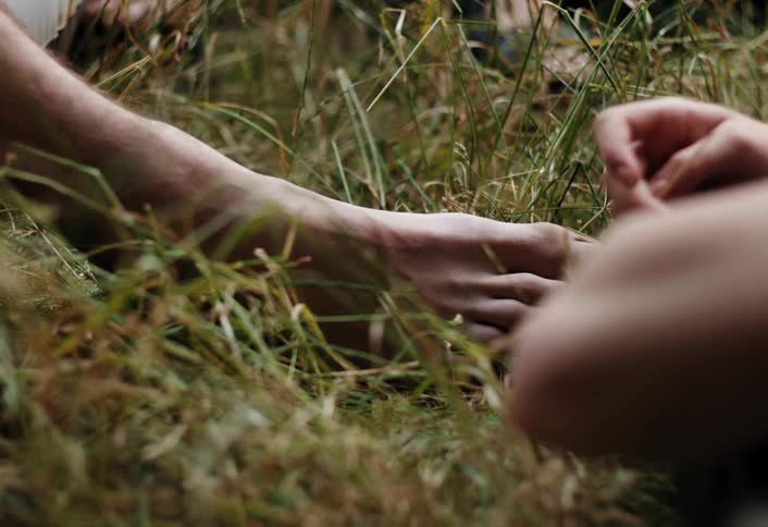 Bare feet and hands are in the grass