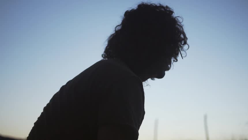 A man is looking up on a sunny day at dawn
