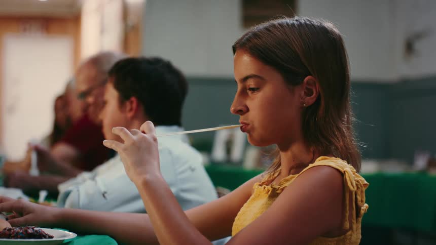 A girl puts gum under her chair