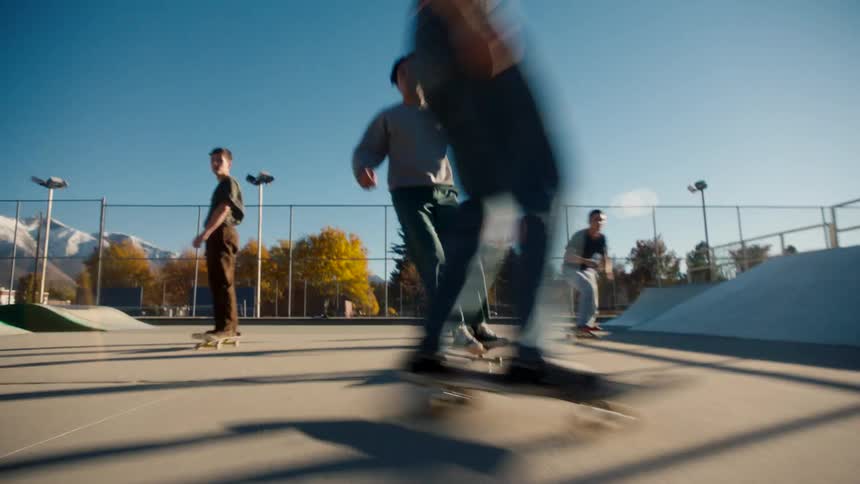 A group of teenagers ride skateboards in the park