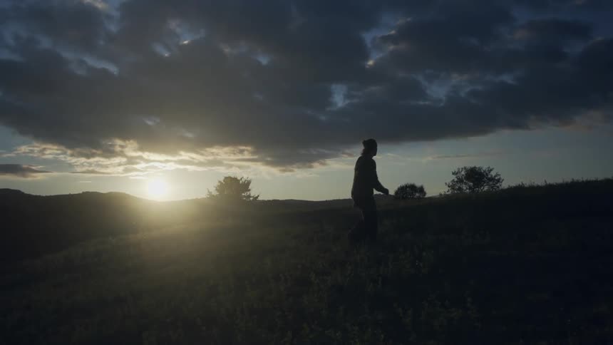 A person is walking uphill at dawn