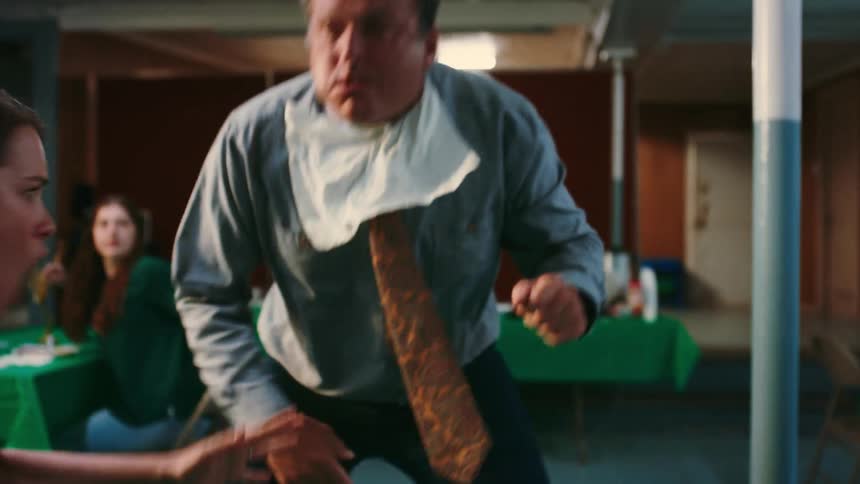 A man begins choking on a hotdog and is given the heimlich maneuver