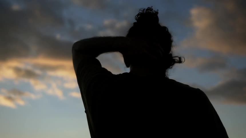 A man walks forward at sunset