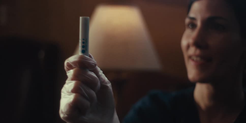 Nurse using a small device near the face of an elderly man