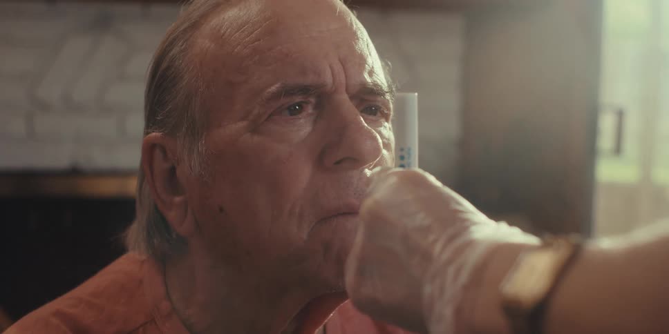 A nurse moves a pen light back and forth in front of the mans face