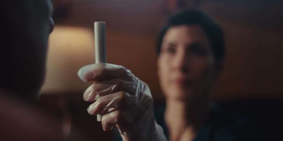 A closeup of a nurse wearing gloves using a medical device to perform a test on a patient
