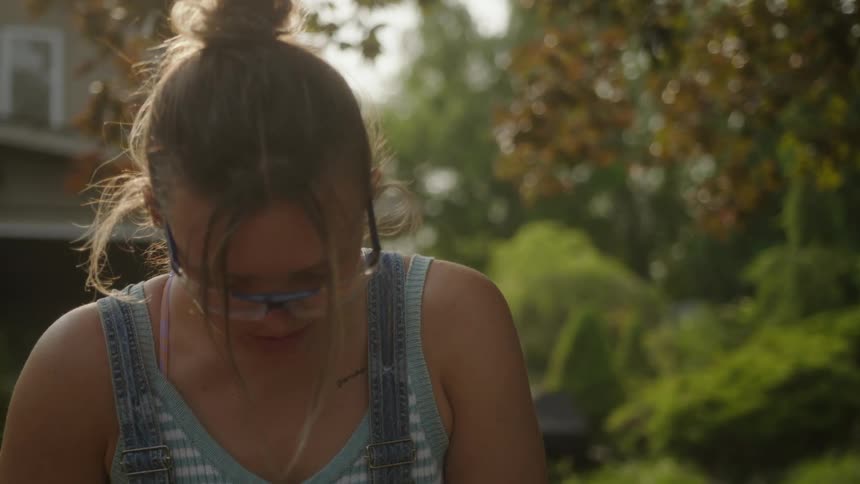A girl is working on something in her yard