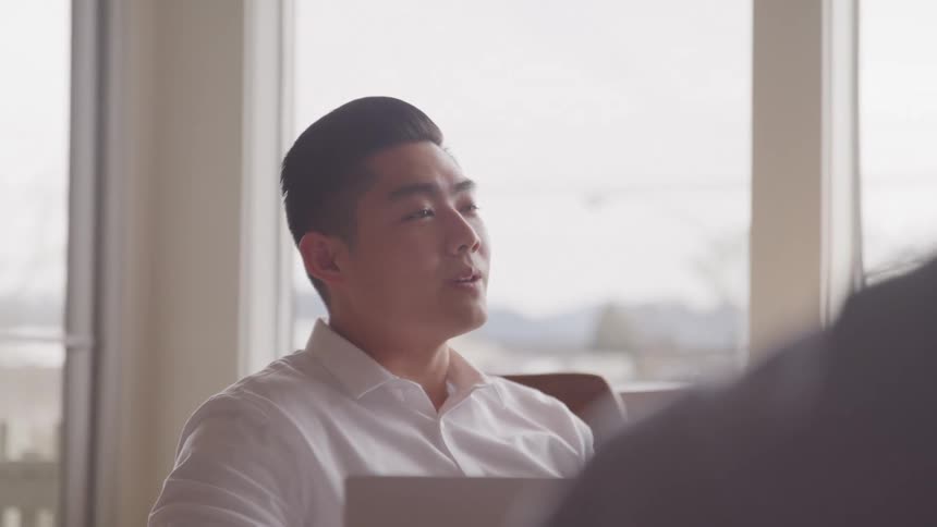 A man is nodding and smiling at a meeting