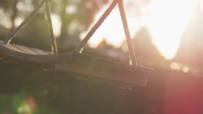 An empty swing swings slowly back and forth